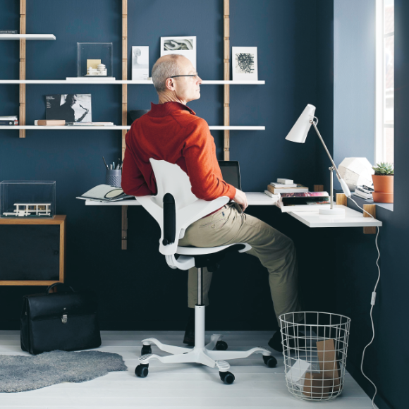 Mann sitzt auf ergonomischem Bürostuhl