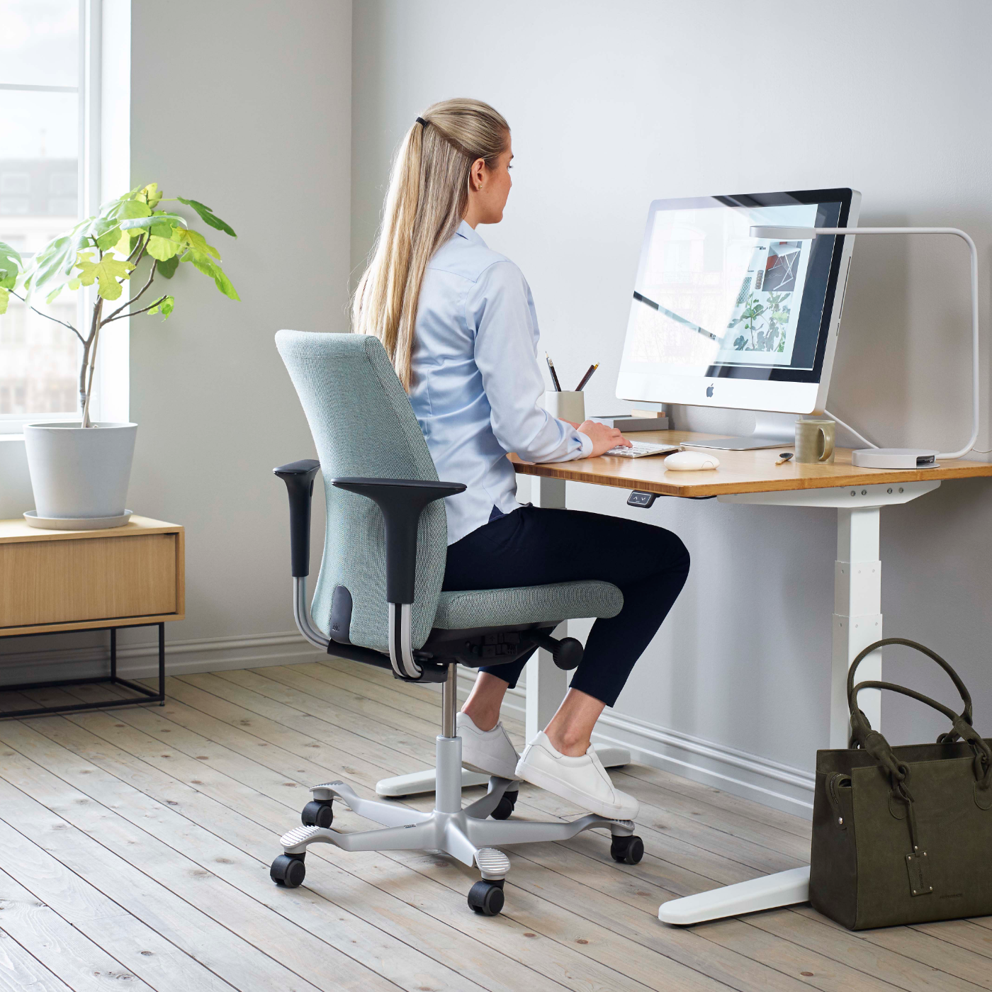 Frau sitzt auf ergonomischem Bürostuhl