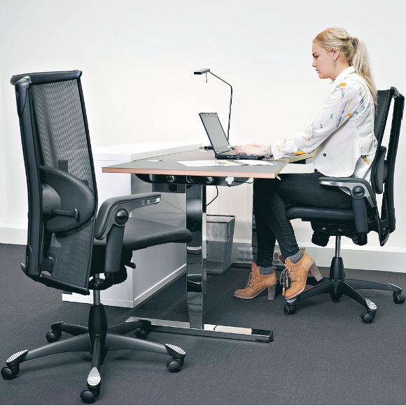 Frau sitzt auf ergonomischem Bürostuhl