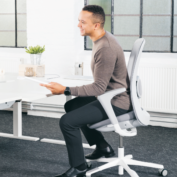 Mann sitzt auf ergonomischem Bürostuhl