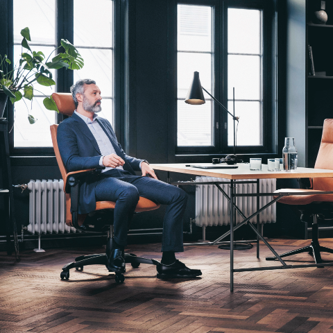 Mann sitzt auf ergonomischem Bürostuhl